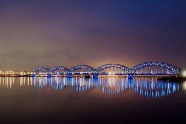 Riga, Letonya - 15 Kasım 2012: Riga demiryolu Köprüsü akşam aydınlatılmış