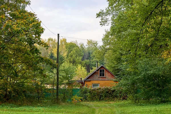 Riga, Letonia - 12 de octubre de 2012: Pequeña casa de madera marrón en las afueras de Riga en el bosque — Foto de Stock