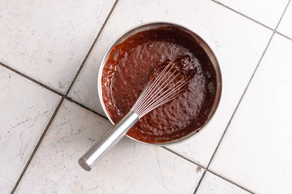 A bowl of chocolate dough and a mixer stand on the tile floor — Stock Photo, Image