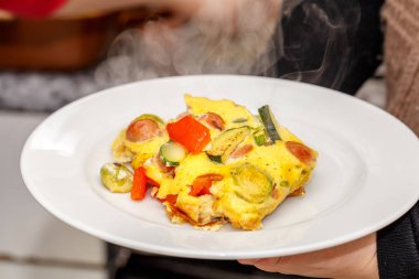 dilimler halinde, sebze sosis ile lezzetli omlet bölümünü kesip