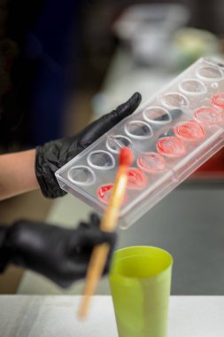 Eldivenli şekerlemeci şekerlemeleri formda yapar.