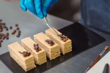 Şekerci kahve taneleriyle süslenmiş çikolatalı kek yapar.