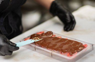 Eldivenli şekerlemeci şekerlemeleri formda yapar.