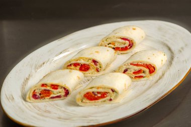 Tabağında otlar olan balıklı rulo.