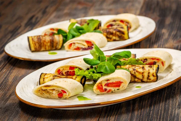 Rolls with fish and eggplant rolls with herbs on a plate — Stock Photo, Image