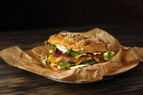 Appetizing hamburger with meat and vegetables on food paper