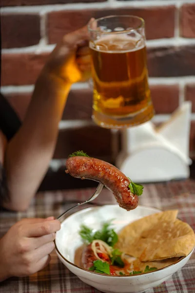 Chica cena en un pub salchichas fritas —  Fotos de Stock