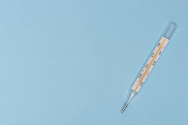 Mavi arkaplandaki civa termometresi, kopyalama alanı, üst görünümü.