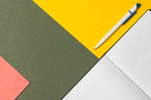 Minimal creative concept, notepad for writing, fountain pen on a colored paper background.