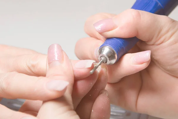 Nail Care Procedure. Nail salon, manicurist polishes a woman\'s nails.