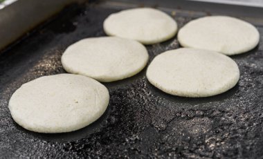 Pişmemiş arepalar, geleneksel Venezuela mısır köfteleri, bir sokak yiyecek pazarında..
