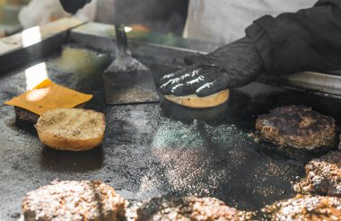 Bir markette aşçı, peynirli et köftesi kızartıyor..