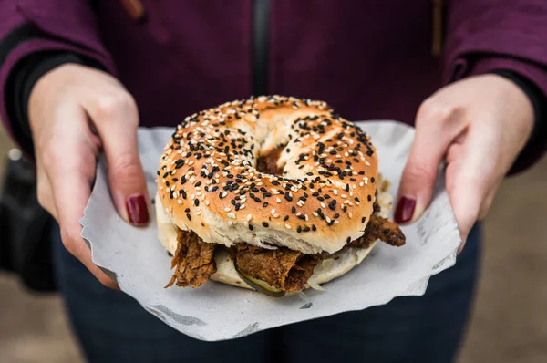 Bagel con carne de pastrami y encurtidos en un mercado callejero de alimentos . — Foto de Stock