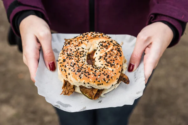 Bagel with pastrami beef meat and pickles at a street food market. — ストック写真