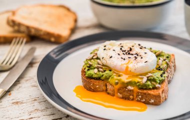 Kavrulmuş yumurtalı avokado tostu. Vejetaryen yemekleri ve sağlıklı beslenme konsepti.