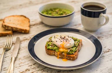 Kavrulmuş yumurtalı avokado tostu. Vejetaryen yemekleri ve sağlıklı beslenme konsepti.