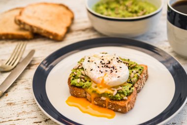 Kavrulmuş yumurtalı avokado tostu. Vejetaryen yemekleri ve sağlıklı beslenme konsepti.