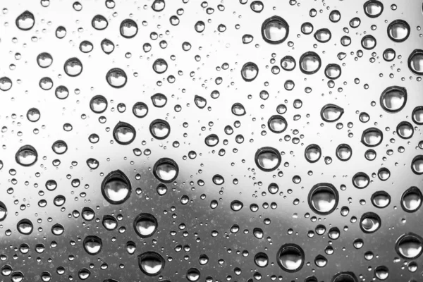 Water drops on glass window grey background after the rain in the autumn fall. — Stock Photo, Image