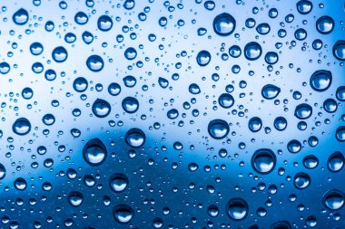 Sonbaharda yağan yağmurdan sonra cam pencereye su damlıyor..