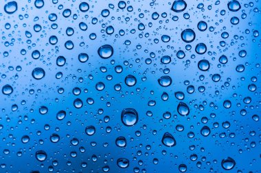 Sonbaharda yağan yağmurdan sonra cam pencereye su damlıyor..