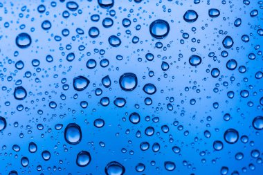 Sonbaharda yağan yağmurdan sonra cam pencereye su damlıyor..