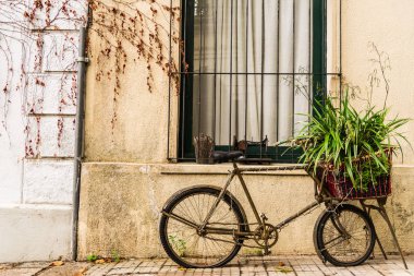 Koloni ve renkli bir evin duvarına karşı eski bir bisiklet..