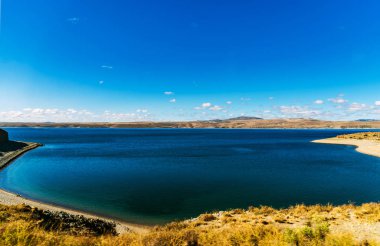 Patagonya, Arjantin 'de turkuaz göl manzarası ve sarı bozkırlar.
