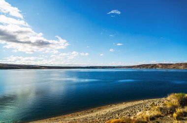 Patagonya, Arjantin 'de turkuaz göl manzarası ve sarı bozkırlar.