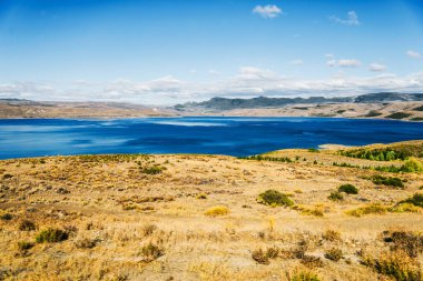 Patagonya, Arjantin 'de turkuaz göl manzarası ve sarı bozkırlar.