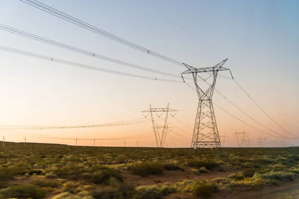 日の出時の電力塔線パイロン. — ストック写真