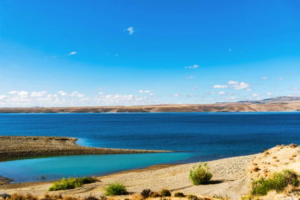 Patagonya, Arjantin 'de turkuaz göl manzarası ve sarı bozkırlar.