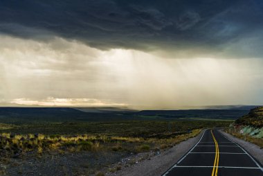Yağmurun arka planı, kara bulutlar, bozkırlar ve Arjantin 'deki dağlar.