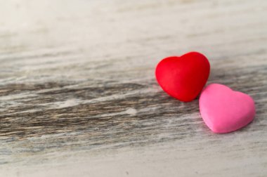 Kırsal beyaz arka plana karşı renkli kırmızı ve pembe kalpler.