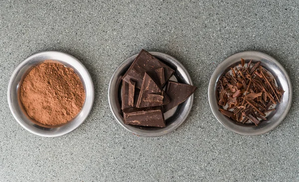 A flat lay view of dark milk chocolate, cocoa powder, and chocolate shavings. — Stock Photo, Image