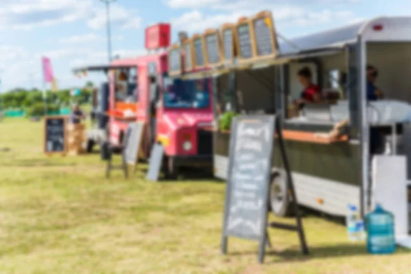 Camion alimentari e persone a un festival del mercato alimentare di strada, offuscati di proposito . — Foto Stock