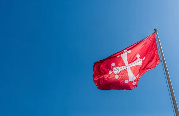 Pisan Cross, de officiële vlag van de provincie Pisa in Italië tegen de blauwe lucht. — Stockfoto