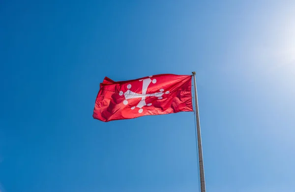 Pisan Haçı, İtalya 'nın Pisa eyaletinin resmi bayrağı mavi gökyüzüne karşı. — Stok fotoğraf