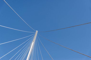 Mavi gökyüzüne karşı bir köprünün soyut geometrik mimari öğeleri.