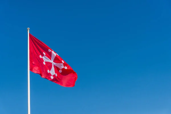 Das Pisanische Kreuz, die offizielle Flagge der Provinz Pisa in Italien vor blauem Himmel. — Stockfoto