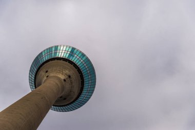 Düsseldorf 'taki Rheinturm telekomünikasyon kulesi bulutlu gökyüzünün arka planında.