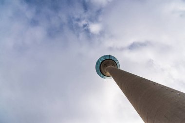 Düsseldorf 'taki Rheinturm telekomünikasyon kulesi bulutlu gökyüzünün arka planında.