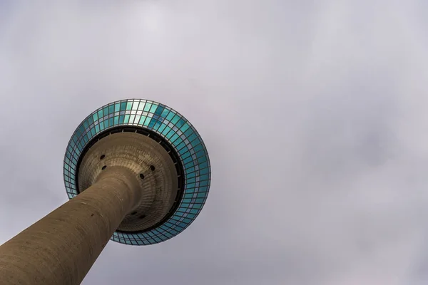 Rheinturm telekommunikációs torony Düsseldorfban a felhős ég hátterében. — Stock Fotó