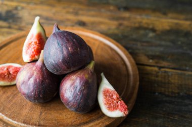 Kahverengi ahşap arka planda incir meyvesi yakın.