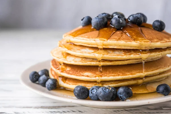 Close up of fluffy pancakes with maple syrup and blueberries. — Stock Photo, Image