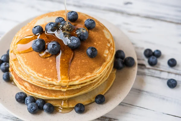 Close up of a stack of fluffy pancakes with maple syrup poured over them. — Stock Photo, Image