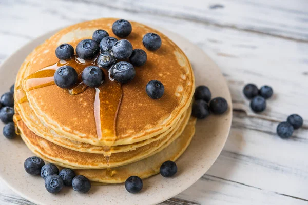 Close up of fluffy pancakes with maple syrup and blueberries. — Stock Photo, Image