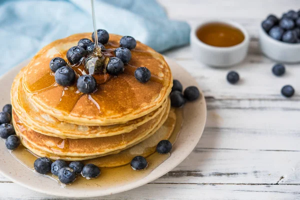 Close up of a stack of fluffy pancakes with maple syrup poured over them. — Stock Photo, Image