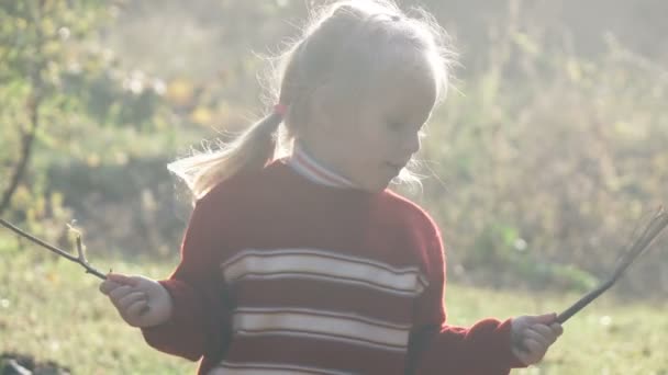 Niña jugando con ramas — Vídeo de stock