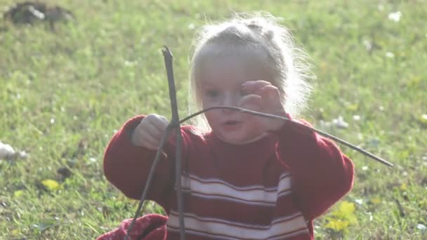 Girl child playing with branches — Stock Video