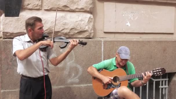 Músicos callejeros tocan guitarra — Vídeo de stock
